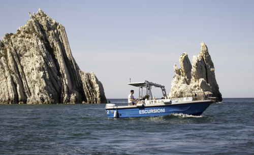 Panoramic view of a boat sailing the waters of the Conero Riviera, between enchanting beaches and bays.