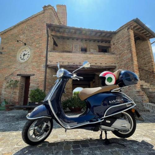 Vespa tour through the rolling hills of Le Marche.Medieval hilltop village with fortifications.Charming narrow streets in an old Italian town.Scenic view from a castle walkway.Village surrounded by nature, forests, and hills.Ancient castle with stone walls and towers.Panoramic road winding through the Marche countryside.