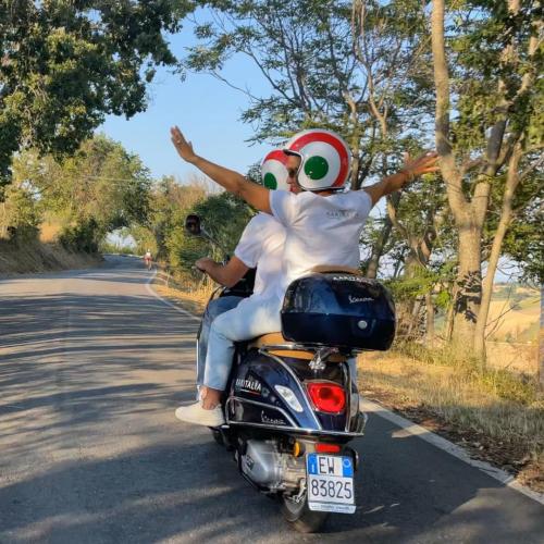 Vespa tour through the rolling hills of Le Marche.Medieval hilltop village with fortifications.Charming narrow streets in an old Italian town.Scenic view from a castle walkway.Village surrounded by nature, forests, and hills.Ancient castle with stone walls and towers.Panoramic road winding through the Marche countryside.